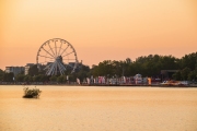 2021.07.23. Hungary, Siofok. Sunrise landsacpe in the lake Balaton. Included with Ferris wheel and Plazs beach. Amazing golden hour colors. It is hotels on the background