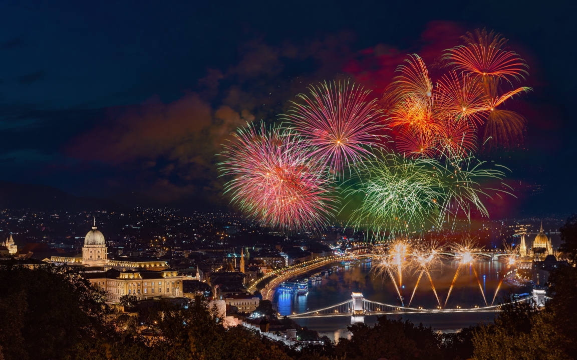 St Sephen memorial day in Budapest Hungary. Celebration fireworks over Danube river. Famous historical Buda castle on the left side  Chain bridge on bottom and Hungarian parliament on  right.
