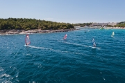 water sports: windsurfers with colored sails in oceanic blue water