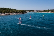 water sports: windsurfers with colored sails in oceanic blue water