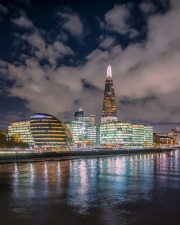 London Cityscape about the bank of Thames river. Amazing skyscrapesrs, cloudly sky and splendid city lights.