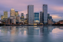 Canary wharf cityscape. The buildings are reflected in Thames river’s water. Canary wharf is the business districet in London City UK.