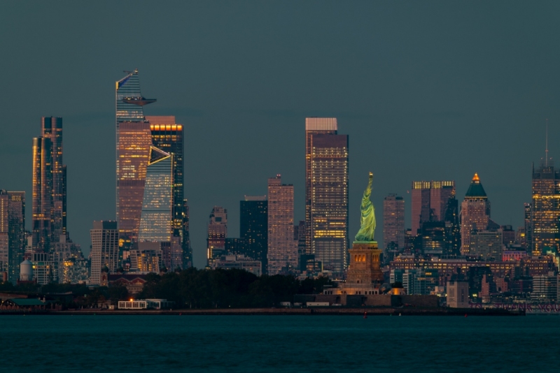 Cityscape landscape in blue hour about New York. included the Statue of liberty. Lady liberty is on the middle New York Skyscrapers is on the background included the famous Edge observation deck too