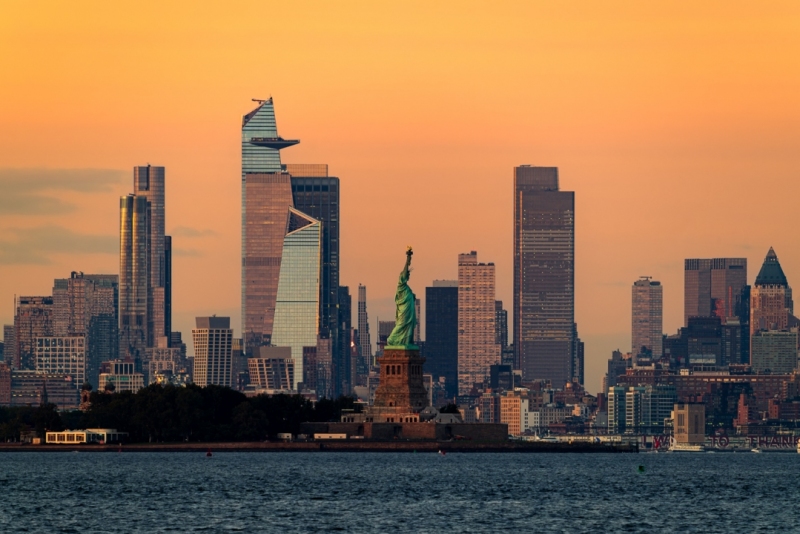 Cityscape landscape in golden hour about New York. included the Statue of liberty. Lady liberty is on the middle New York Skyscrapers is on the background included the famous Edge observation deck too
