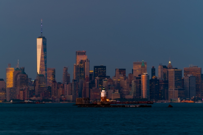 Cityscape landscape at blue hour about New York. included the robbins reef lighthouse. New York Skyscrapers is on the background included the famous One world trade center too