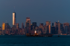 Cityscape landscape at blue hour about New York. included the robbins reef lighthouse. New York Skyscrapers is on the background included the famous One world trade center too