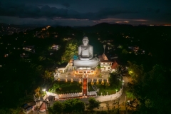 A panoramic view of Kandy, Sri Lanka, showcasing a vibrant cityscape nestled amidst lush green hills, with traditional buildings, bustling streets, and rich cultural landmarks.
