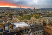 Amazing roof in Budapest, Hungary. State Treasury building with Hungarian Parliament in winter time.    All tiles on the roof made from the world famous Zsolnay pyro granite. Rootfop ice rink in the foreground.