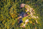 Flooded ancient stone quarry in Hungary near Sarospatak. Megyer-hegyi tengerszem. Small lake at the top of a hill. View from the top. Fantastic nature attraction in Tokaj area.